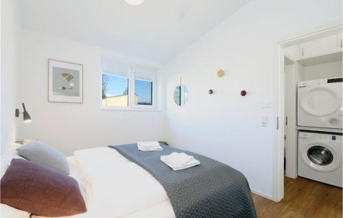 a white room with a bed and a washing machine at Nice Home In Lembruchdümmer See in Lembruch
