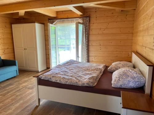 Vysoká nad KysucouにあるDrevenice Horné Kysuceの木製の部屋にベッド1台が備わるベッドルーム1室があります。