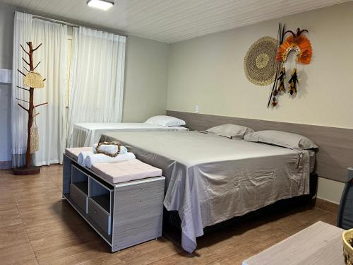 a bedroom with two beds and a table in it at Pousada do Lago Boutique in Santarém