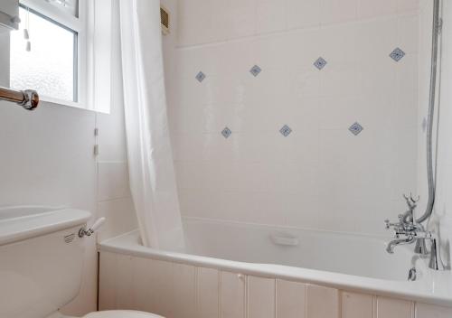 a bathroom with a tub and a toilet and a sink at Egg Cottage in Holt