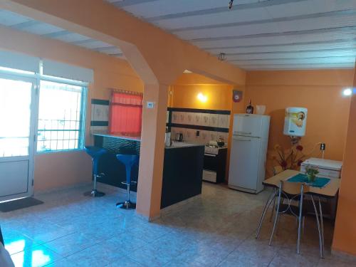 a kitchen with a refrigerator and a table and chairs at La Candela 1 casa in Villa Lonca