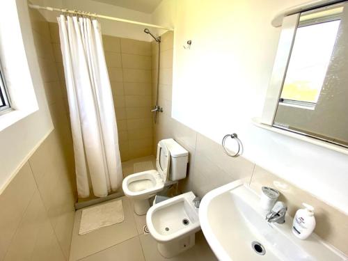 a white bathroom with a toilet and a sink at Loft de Mar in José Ignacio