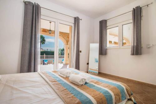 sypialnia z łóżkiem i dużym oknem w obiekcie Villa Noa - PlusHolidays w mieście Calpe