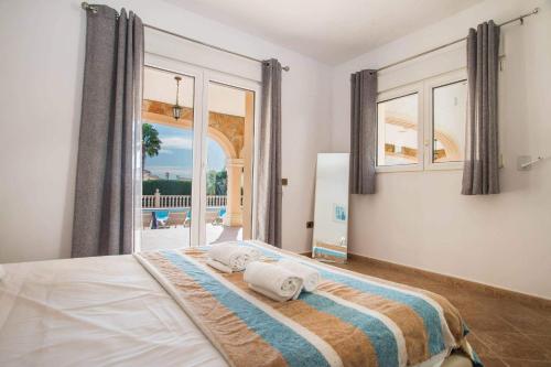 a bedroom with a bed and a large window at Villa Noa - PlusHolidays in Calpe