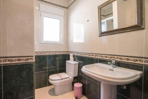 łazienka z umywalką, toaletą i lustrem w obiekcie Villa Noa - PlusHolidays w mieście Calpe