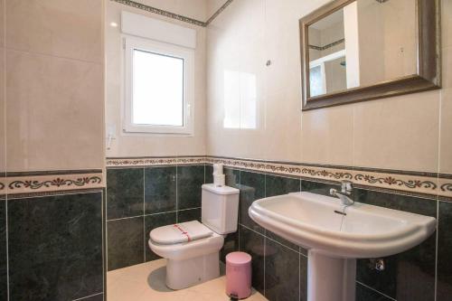 a bathroom with a sink and a toilet and a mirror at Villa Noa - PlusHolidays in Calpe