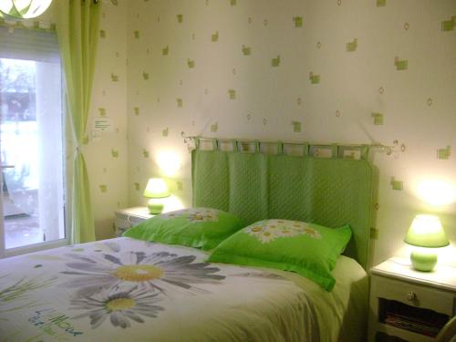 a bedroom with a bed with green sheets and pillows at La ferme de la Velle in La Neuvelle-lès-Scey