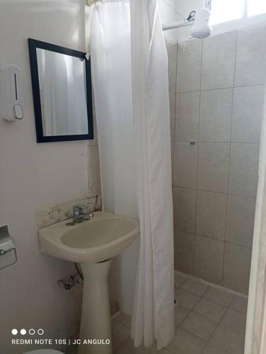 a bathroom with a sink and a shower with a mirror at Depa sencillo, 10 min malecon in Mazatlán