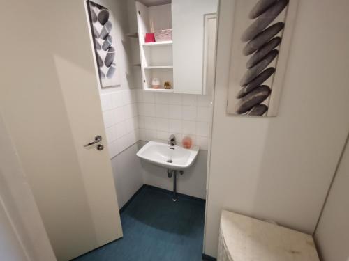 uma pequena casa de banho com um lavatório e um espelho em Relaxing Beatiful Studio - Sauna Bath Facility em Kotka