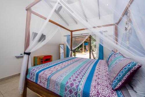 um quarto com uma cama de dossel em Surfside Mar Y Posa em Playa Flamingo