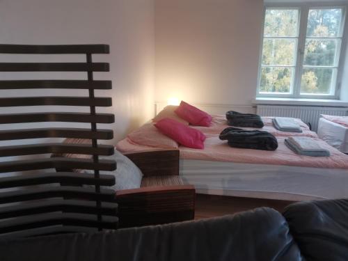 uma cama com almofadas cor-de-rosa num quarto em Relaxing Beatiful Studio - Sauna Bath Facility em Kotka