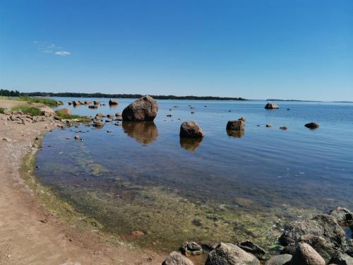a group of rocks in the water on a beach at Relaxing Beatiful Studio - Sauna Bath Facility in Kotka