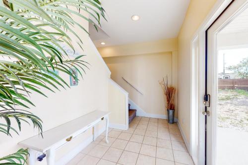 a hallway with a white bench and a plant at Shore To C in St. George Island