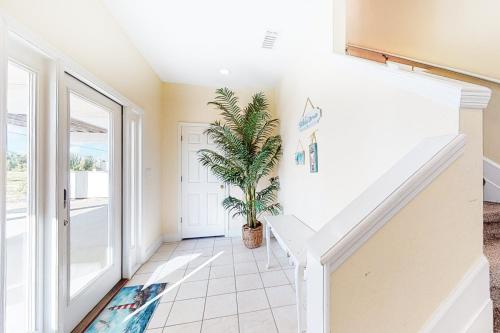 a hallway with a staircase and a potted plant at Shore To C in St. George Island