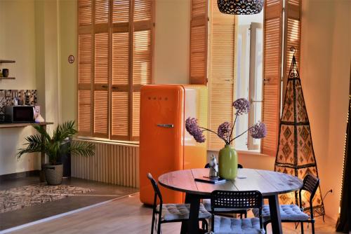 a dining room with a table and a refrigerator at SLEEP INN - 1001 Nights Loft Citycenter with Balconyview in Antwerp