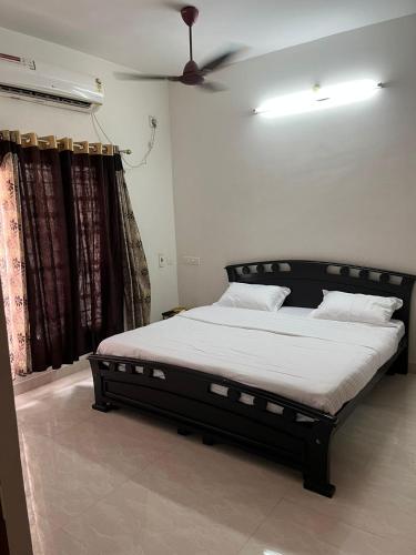 a bed in a bedroom with a ceiling fan at Sapphire Luxury Apartment in Puducherry