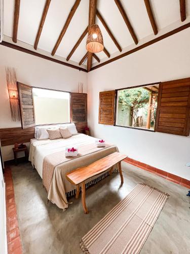 ein Schlafzimmer mit einem Bett und einem großen Fenster in der Unterkunft Bangalô de Charme na Praia do Patacho - Rota Ecológica dos Milagres in Pôrto de Pedras