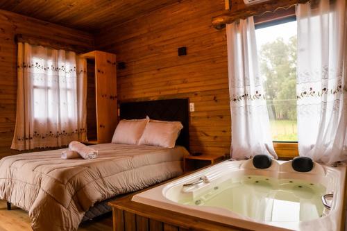 um quarto com uma cama e uma banheira em Pousada Caminhos da Serra em Bom Retiro