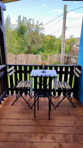 Ein Tisch und zwei Stühle auf einer Holzterrasse in der Unterkunft La Casuta in Fieni