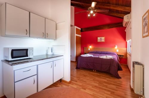 a bedroom with a bed and a red wall at Balcón de Nono in Nono