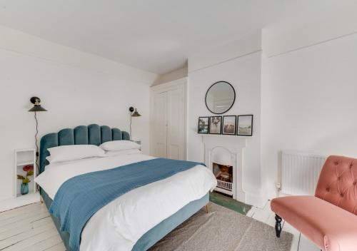 a bedroom with a bed and a chair and a fireplace at Felixstowe Beach House in Felixstowe