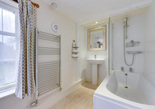 a white bathroom with a tub and a sink at Appletree Cottage in Westleton