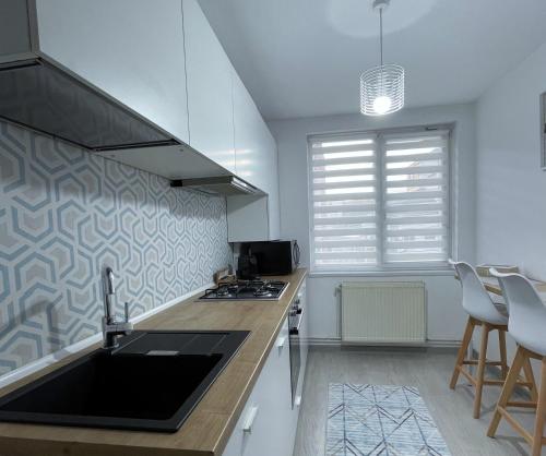 a kitchen with a sink and a counter top at Inga Apartment in Turda