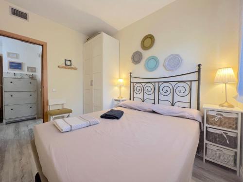 - une chambre avec un lit blanc et 2 serviettes dans l'établissement Coma-Ruga Beach Apartment, à Tarragone