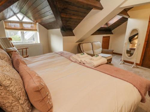 een slaapkamer met een groot bed en een stoel bij No 2 The Mews in Carnforth