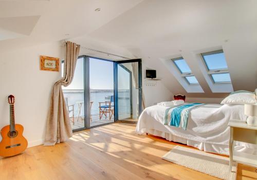 a bedroom with a bed and a balcony with a guitar at Admiralty Lodge in Shotley Gate