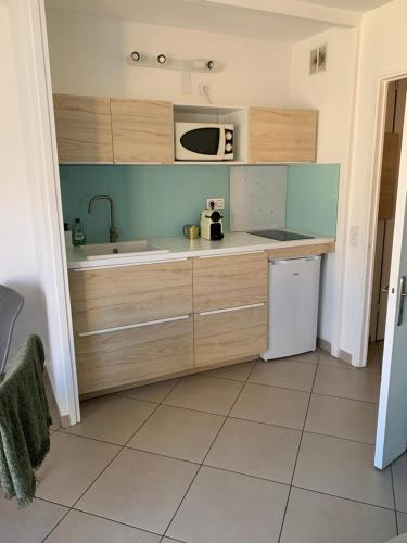 une cuisine avec un évier et un micro-ondes dans l'établissement Joli Studio proche quartier Timone Climatisé, à Marseille