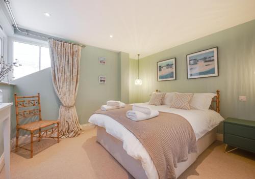 a bedroom with a bed and a chair and a window at Barley Rise in Southwold