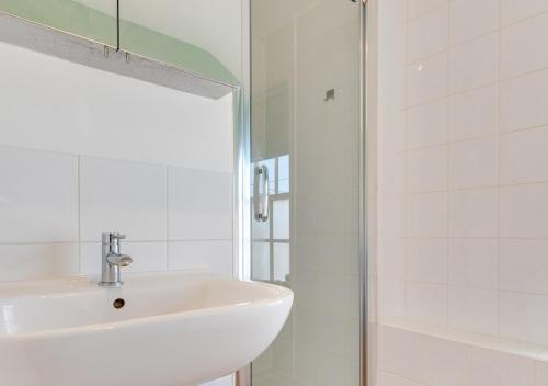 a white bathroom with a sink and a shower at Brightseas in Southwold
