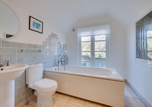 a bathroom with a tub and a toilet and a sink at Gabriels Place in Walsham le Willows