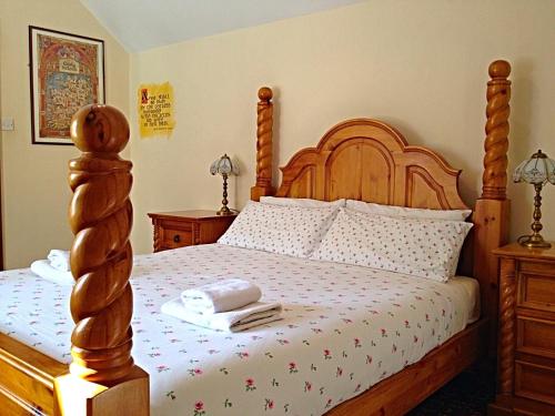 1 dormitorio con cama de madera y cabecero de madera en Cashel Town Center INN, en Cashel