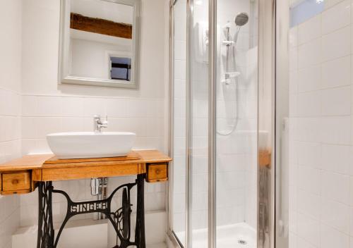 a bathroom with a sink and a shower at London Cottage in Halesworth