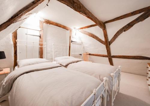 2 camas individuais num quarto com vigas em London Cottage em Halesworth