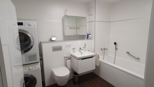 bagno bianco con lavandino e lavatrice di moderne 4 Zimmer -Wohnung I BBQ I Parkplatz a Monaco