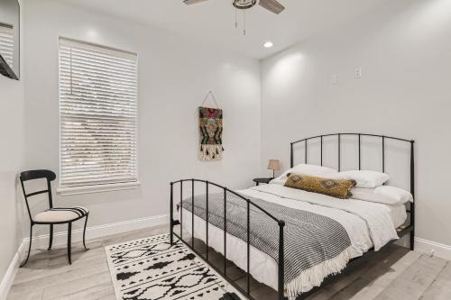 a bedroom with a black bed and a chair at Luxury 5 BDRM Home! Blocks To DT/Riverwalk/Convention Center! in San Antonio