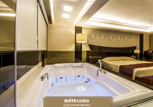 a bath tub in a hotel room with a bed at San Marco Hotel Brasília in Brasilia