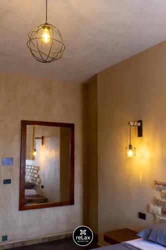 a bedroom with two lights and a mirror at relax hotelito in Cárdenas