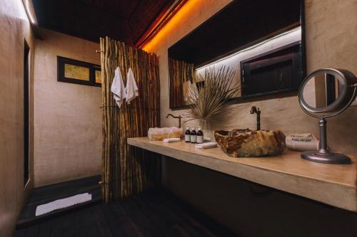 a bathroom with a sink and a mirror on a counter at Radhoo Tulum in Tulum