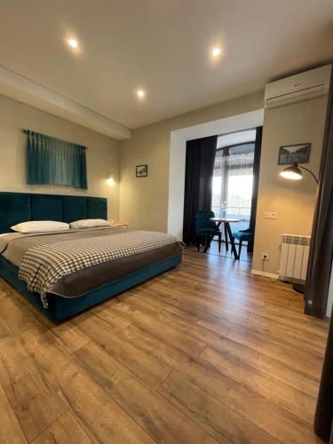 Schlafzimmer mit einem Bett und Holzboden in der Unterkunft Home Aparts in Saporischschja