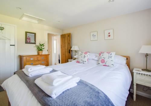 a bedroom with a large white bed with towels on it at Larksfield Snug in Debach