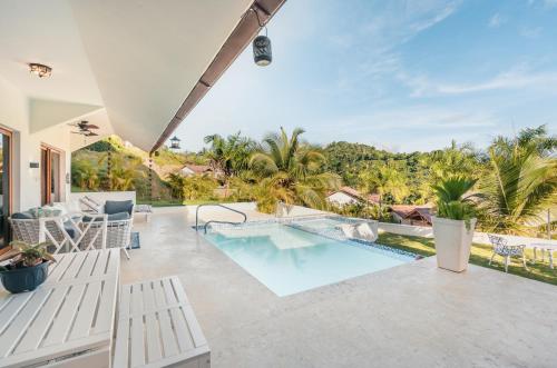 an outdoor patio with a swimming pool and a resort at Villa with 3 bedrooms private pool and ocean view in Santa Bárbara de Samaná