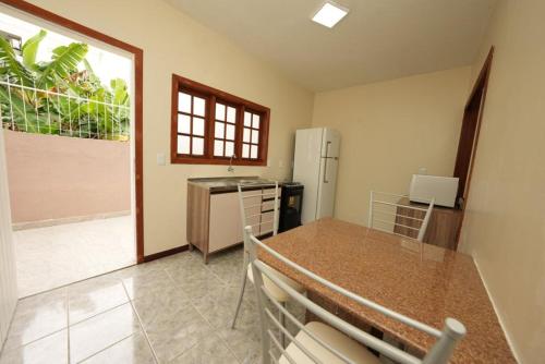 uma cozinha com uma mesa e um frigorífico em Apartamento Vera em Florianópolis