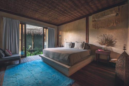 - une chambre avec un grand lit et un balcon dans l'établissement Radhoo Tulum, à Tulum