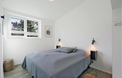 een witte slaapkamer met een bed en 2 ramen bij Nice Home In Lembruch-dmmer See With Sauna in Lembruch