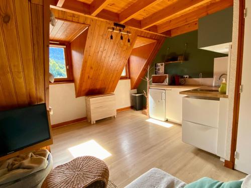 Il comprend une cuisine avec des murs en bois et du parquet. dans l'établissement Appartement Chalet à 1400m - Station du Mourtis, à Boutx