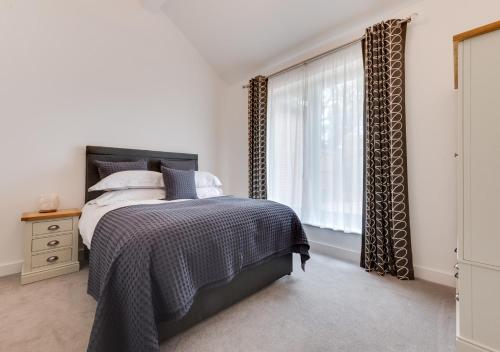 um quarto com uma cama e uma janela em Bramble Cottage em Leiston